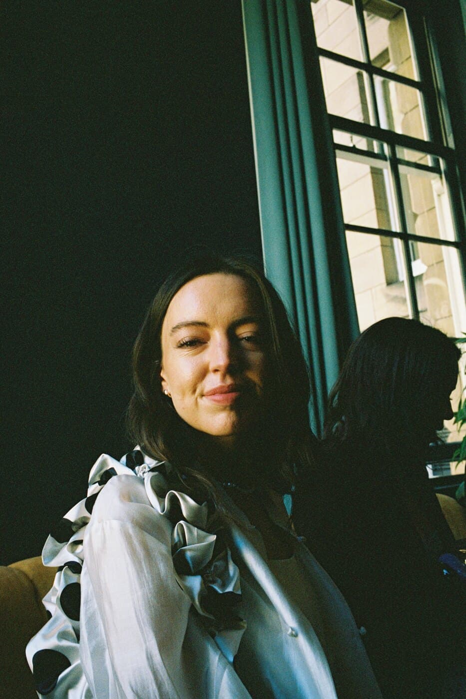 Becca by a window on her wedding day